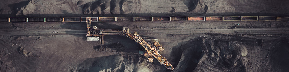 Large-scale mining operation with excavation and rail cars